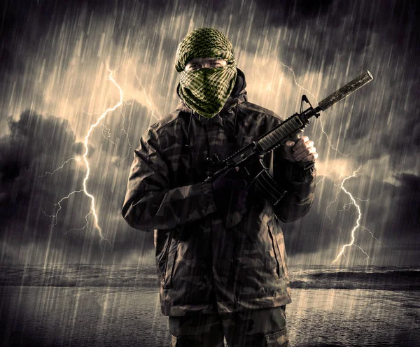 Gefährlicher bewaffneter Terrorist mit Maske und Waffe im Gewitter — Stockfoto