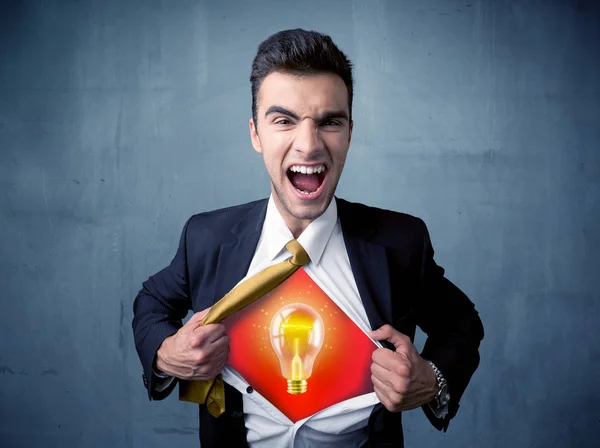 Businessman ripping off shirt and idea light bulb appears — Stock Photo, Image