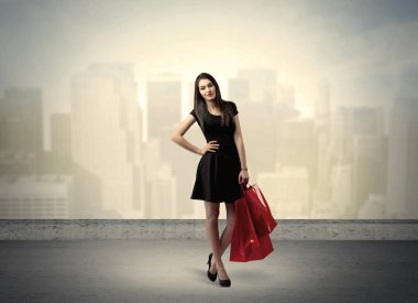 Alışveriş torbalarıyla duran şehir kadını.