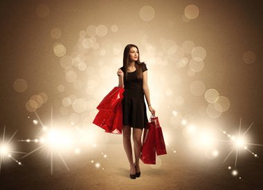 Parlak ışıklarda çantalı alışveriş yapan kadın.