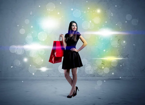 Senhora do shopping com sacos de compras e luz de brilho — Fotografia de Stock