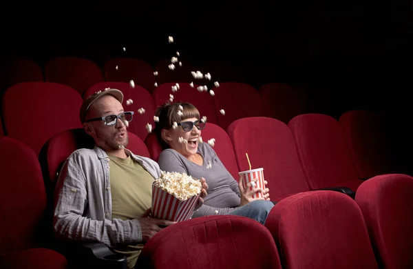 Молодая пара сидит в красном кинотеатре — стоковое фото