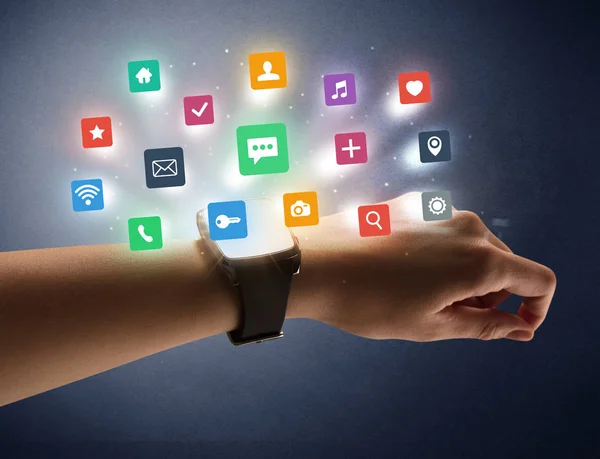 Main féminine portant smartwatch avec des icônes app — Photo