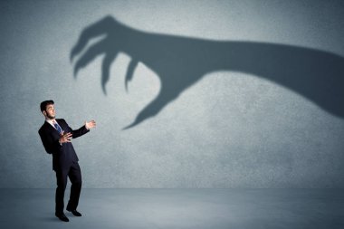 İş kişi büyük canavar pençe gölge kavramı korkuyor