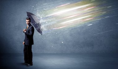 Şemsiye konseptiyle ışık demetlerini savunan iş adamı