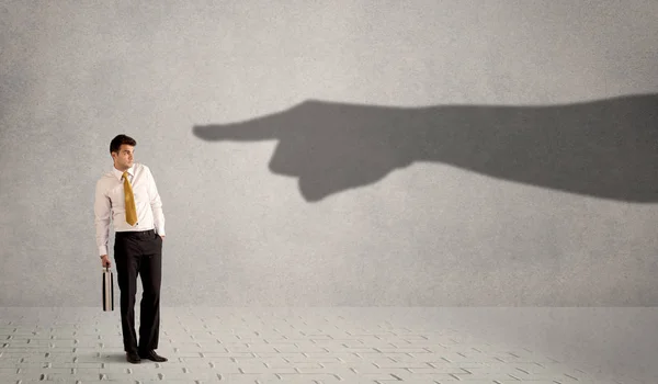 Persona de negocios mirando enorme sombra mano apuntando a él conc — Foto de Stock