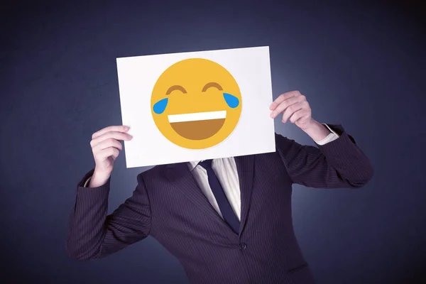 Бізнесмен тримає папір зі сміховинним емоційок — стокове фото