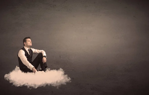男子坐在云与朴素的背景 — 图库照片