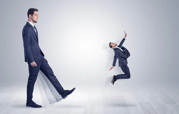 Gigante empresário chutando para fora pequeno empresário — Fotografia de Stock