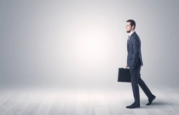 Businessman walking in front of an empty wall — Stock Photo, Image