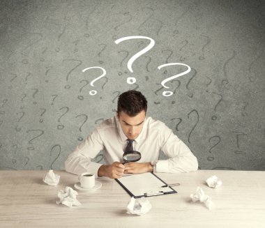 İş adamı soru işaretiyle masada.