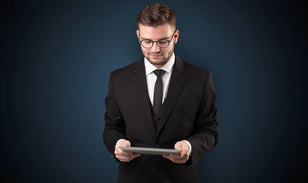 Empresário segurando tablet com fundo escuro — Fotografia de Stock