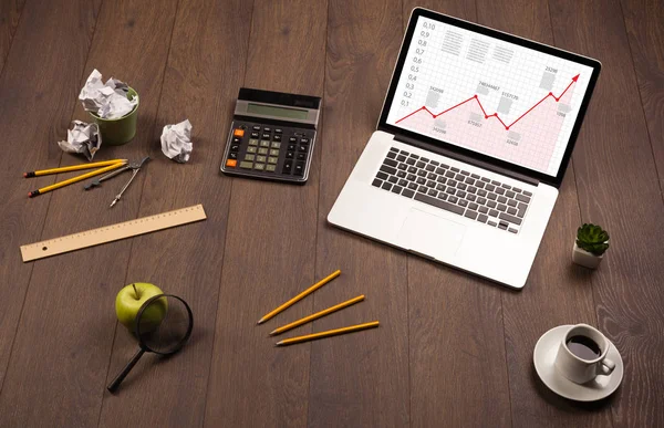 Mesa de computador com laptop e gráfico de seta vermelha na tela — Fotografia de Stock