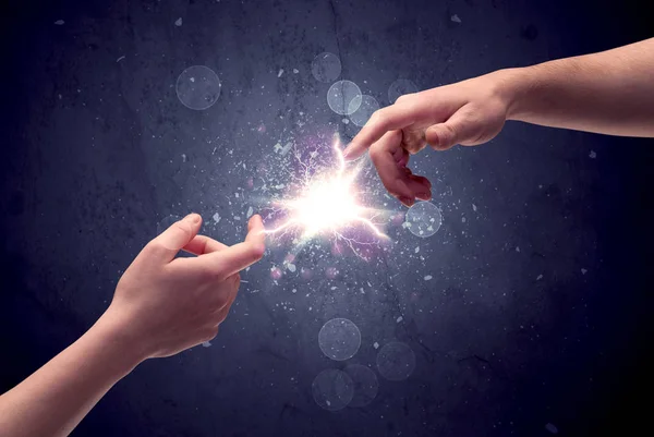 Hands reaching to light a spark — Stock Photo, Image