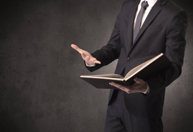 Elinde kitap tutan bir işadamı.