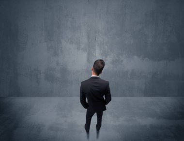 Şehir duvarının önünde duran iş adamı