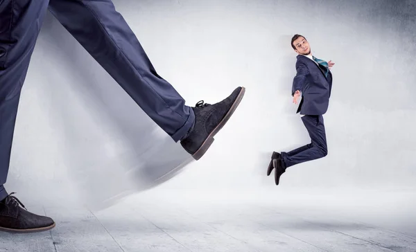 Big leg kicking small man — Stock Photo, Image