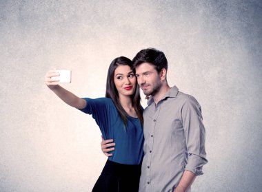 Mutlu çift temiz duvarlı selfie çekiyor.