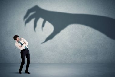 İş kişi büyük canavar pençe gölge kavramı korkuyor