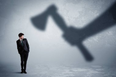 İşadamı bir balta kavramı tutan bir büyük gölge el korkuyor