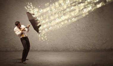 İş adamı dolar yağmuruna karşı şemsiye tutuyor