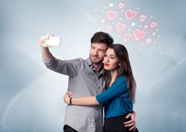 Aşık çift kırmızı kalple selfie çekiyor.