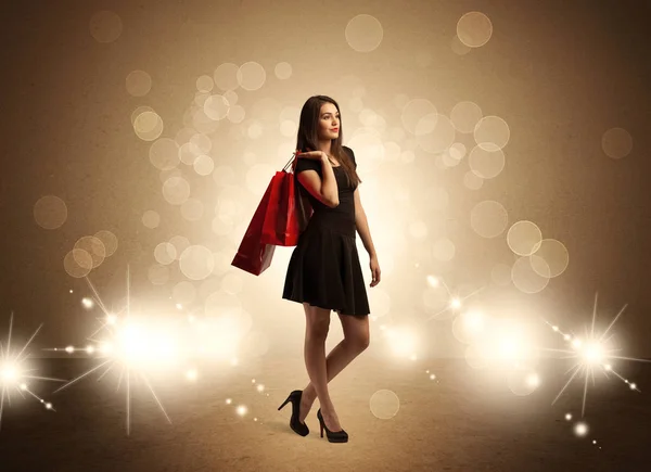 Shopping lady with bags in bright lights — Stock Photo, Image