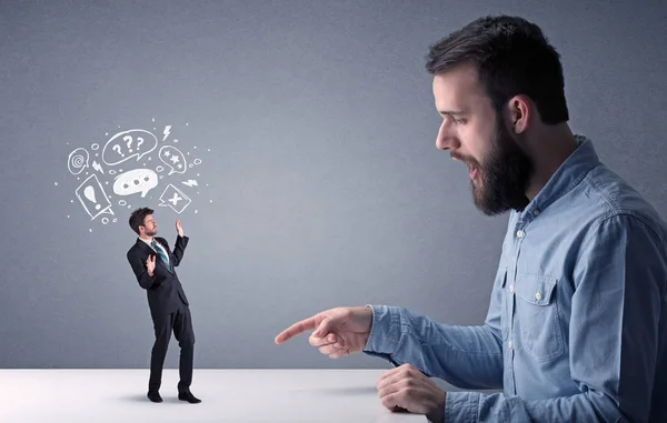 Young businessman fighting with miniature businessman — Stock Photo, Image