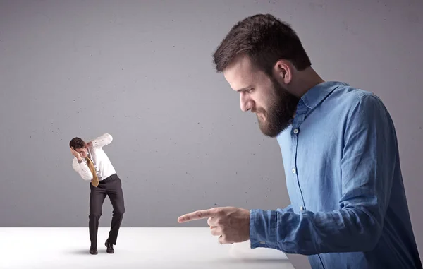 Joven hombre de negocios luchando con empresario en miniatura —  Fotos de Stock