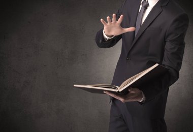 Elinde kitap tutan bir işadamı.