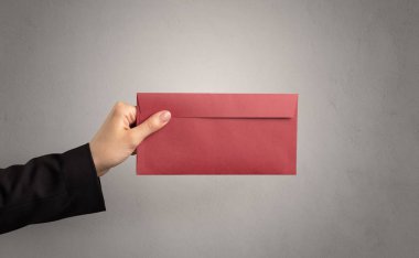 Zarf boş duvar arka plan ile tutan el