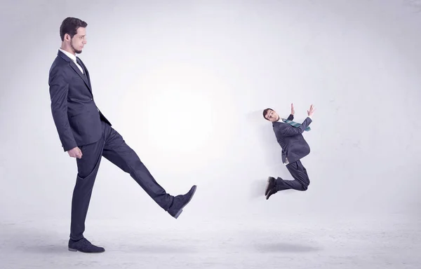 Grande homem chutando pouco ele mesmo para fora — Fotografia de Stock