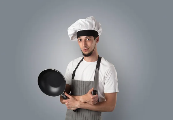 Кухар з кухонними інструментами і порожніми шпалерами — стокове фото