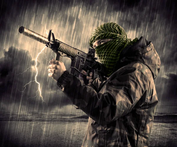 Gefährlicher bewaffneter Terrorist mit Maske und Waffe im Gewitter — Stockfoto