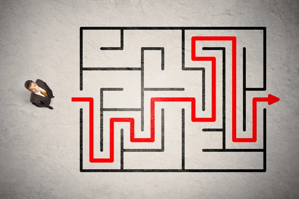 Homme d'affaires perdu trouvé le chemin dans le labyrinthe avec flèche rouge — Photo