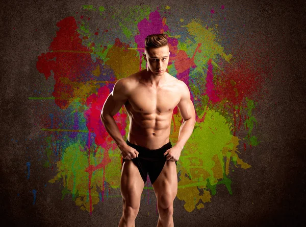 Sterke kerel met kleurrijke verf muur en gewicht — Stockfoto