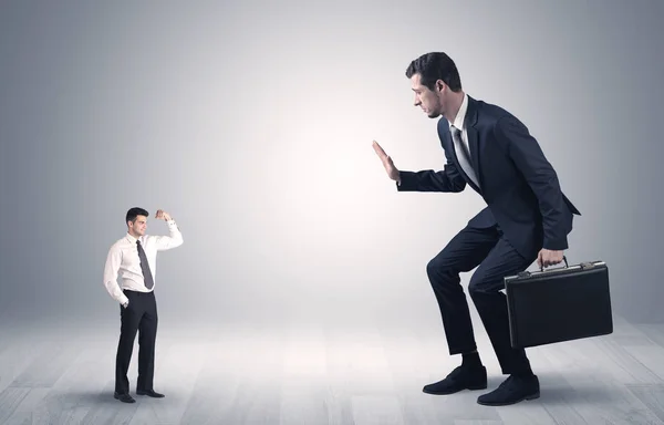 Hombre de negocios gigante asustado de hombre de negocios pequeño — Foto de Stock