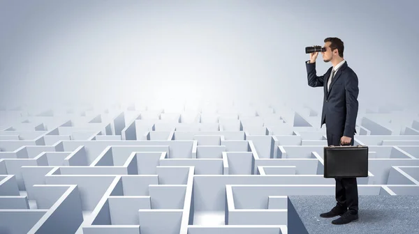 Man står på toppen av en labyrint med kikare — Stockfoto