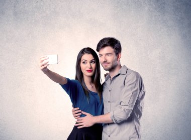 Mutlu çift temiz duvarlı selfie çekiyor.