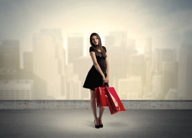 Alışveriş torbalarıyla duran şehir kadını.