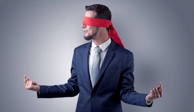 Kapalı göz işadamı bir duvarın önünde