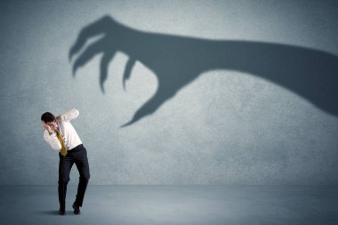 İş kişi büyük canavar pençe gölge kavramı korkuyor