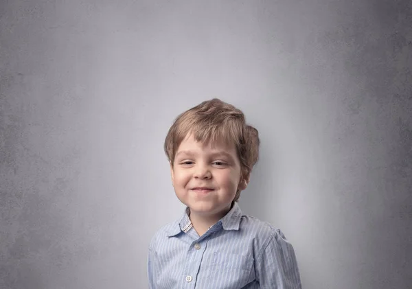 Entzückender kleiner Junge vor einer leeren Wand — Stockfoto