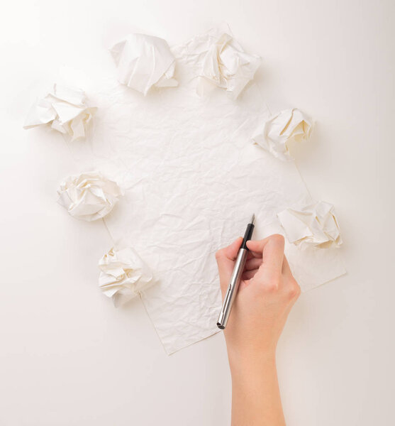 Writing hand in crumpled paper