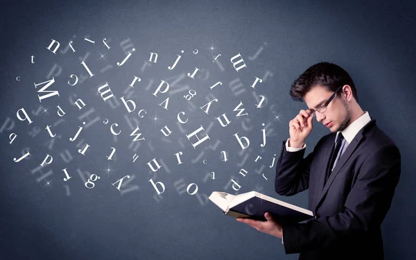 Young man holding book with letters — Stock Photo, Image