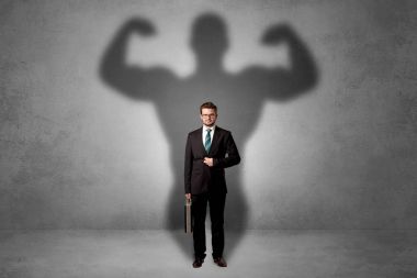 Businessman with muscular shade behind his back clipart