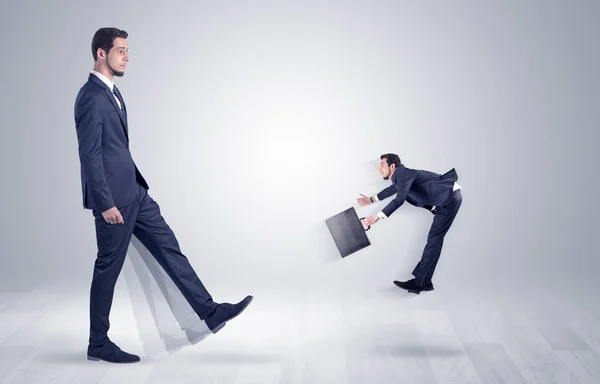 Giant businessman kicking out little businessman — Stock Photo, Image