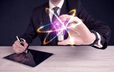 renkli bir ampul tutan işadamı