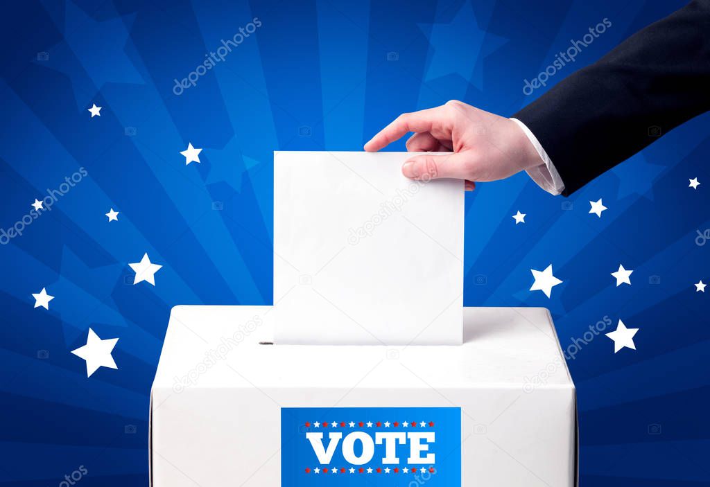 hand with ballot and wooden box