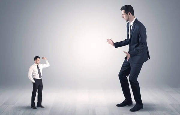 Hombre de negocios gigante asustado de hombre de negocios pequeño —  Fotos de Stock